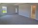 Bright bedroom with plush carpet and a view into the ensuite bathroom and backyard at 13334 Ogden Glade Rd, Dade City, FL 33525