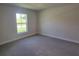 Empty bedroom with carpet flooring and a large window at 13334 Ogden Glade Rd, Dade City, FL 33525