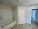Bathroom showcasing a tub with tile surround and wood-look tile flooring at 13374 Ogden Glade Rd, Dade City, FL 33525