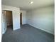 An open bedroom featuring neutral walls and carpeting with a closet and access to another room at 13374 Ogden Glade Rd, Dade City, FL 33525