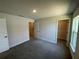 Spacious bedroom showcasing multiple doorways and plush carpeting at 13374 Ogden Glade Rd, Dade City, FL 33525