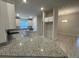 Modern kitchen featuring white cabinets, granite countertops, stainless steel appliances, and an island at 13374 Ogden Glade Rd, Dade City, FL 33525