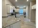 Bright kitchen showcasing white cabinets, granite countertops, stainless steel appliances, and tile flooring at 13374 Ogden Glade Rd, Dade City, FL 33525