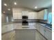 Kitchen featuring granite countertops, stainless steel appliances, white cabinetry, and a center island at 13374 Ogden Glade Rd, Dade City, FL 33525