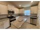 Well-lit kitchen with granite countertops, stainless steel appliances, white cabinets, and an island at 13374 Ogden Glade Rd, Dade City, FL 33525