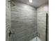 Shower features sleek gray tile, glass door and modern fixtures at 13374 Ogden Glade Rd, Dade City, FL 33525