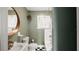 Charming bathroom with black and white tiled floor, large round mirror, and shower/tub combo at 1513 W Mohawk Ave, Tampa, FL 33603