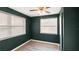 Bedroom with dark green walls, ceiling fan, blinds on the windows, and wood floor at 1513 W Mohawk Ave, Tampa, FL 33603