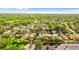 Birds-eye view highlighting a leafy suburb dotted with comfortable homes, adjacent to a commercial zone at 1667 E Orangeside Rd, Palm Harbor, FL 34683