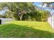 Expansive backyard offering a lush lawn, privacy fence, and mature trees for shade at 1667 E Orangeside Rd, Palm Harbor, FL 34683
