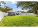 Large backyard with green grass, mature trees, fenced perimeter, and a private pool area at 1667 E Orangeside Rd, Palm Harbor, FL 34683