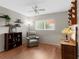 Well-lit bedroom with hardwood floors, a ceiling fan, and a view of outdoor landscaping through a window at 1667 E Orangeside Rd, Palm Harbor, FL 34683