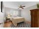A cozy bedroom featuring a neutral rug, wood floors, and a ceiling fan at 1667 E Orangeside Rd, Palm Harbor, FL 34683