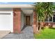 Front entrance of home featuring brick accents and a decorative glass door at 1667 E Orangeside Rd, Palm Harbor, FL 34683