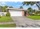 Inviting single-Gathering home with a two-car garage and verdant front lawn at 1667 E Orangeside Rd, Palm Harbor, FL 34683