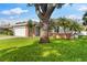 Attractive ranch-style house with lush green lawn and mature landscaping at 1667 E Orangeside Rd, Palm Harbor, FL 34683