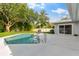 Relaxing pool area with lush green lawn, mature trees, and access to the home at 1667 E Orangeside Rd, Palm Harbor, FL 34683