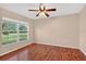 Bedroom featuring wood floors, a ceiling fan, neutral colored walls, and a large window with backyard views at 1822 Sassafras Dr, Wesley Chapel, FL 33543