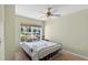 Bright bedroom featuring a ceiling fan and a large window overlooking a beautiful landscape at 1822 Sassafras Dr, Wesley Chapel, FL 33543