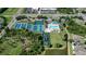 Aerial view of community amenities with a pool, tennis courts, playground, and green spaces for recreation at 1822 Sassafras Dr, Wesley Chapel, FL 33543