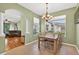 Light-filled dining room featuring a chandelier, views of the backyard, and an archway to the living room at 1822 Sassafras Dr, Wesley Chapel, FL 33543
