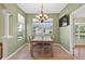 Dining room with green walls, tile floors, and a chandelier above a wooden table with seating for four at 1822 Sassafras Dr, Wesley Chapel, FL 33543