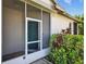 Screened entryway with a charming front door and lush, mature landscaping at 1822 Sassafras Dr, Wesley Chapel, FL 33543