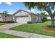 Charming one-story home with a two-car garage, beautiful landscaping, and a well-maintained lawn at 1822 Sassafras Dr, Wesley Chapel, FL 33543
