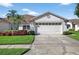 Charming single-story home featuring a two-car garage and lush landscaping at 1822 Sassafras Dr, Wesley Chapel, FL 33543