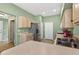 Kitchen with stainless steel refrigerator, wood cabinetry, green walls, and a view to the hallway at 1822 Sassafras Dr, Wesley Chapel, FL 33543