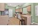 Kitchen featuring tile flooring, wood cabinetry, stainless sink, white appliances, and a breakfast bar at 1822 Sassafras Dr, Wesley Chapel, FL 33543