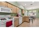 Kitchen featuring tile floors, a breakfast bar, wood cabinets, and an archway to a sunny dining room at 1822 Sassafras Dr, Wesley Chapel, FL 33543