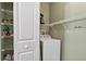 Laundry room with white washer, shelving, and a view into the pantry at 1822 Sassafras Dr, Wesley Chapel, FL 33543