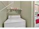 Laundry area with a white washing machine, shelves, and green walls at 1822 Sassafras Dr, Wesley Chapel, FL 33543