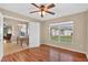 Open room with wood floors, a ceiling fan, archway to the dining room, and a window with backyard views at 1822 Sassafras Dr, Wesley Chapel, FL 33543