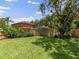 Spacious backyard with lush lawn, wooden fence, and mature trees at 18930 Wood Sage Dr, Tampa, FL 33647