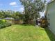 Expansive backyard with lush green grass, mature trees, and a pool enclosure at 18930 Wood Sage Dr, Tampa, FL 33647