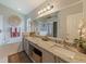 Bathroom features a double sink granite countertop vanity with large mirror, soaking tub, and white tile at 18930 Wood Sage Dr, Tampa, FL 33647