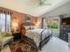 Cozy bedroom with floral bedding, carpeted floors, a ceiling fan, and a view of the backyard at 18930 Wood Sage Dr, Tampa, FL 33647