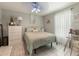 The bedroom has bright natural light from the sheer curtains and a classic ceiling fan at 18930 Wood Sage Dr, Tampa, FL 33647