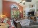 Relaxing living room with a large arched window, brick wall, ceiling fan, and comfortable seating at 18930 Wood Sage Dr, Tampa, FL 33647