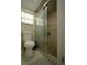 Bathroom featuring tiled walls, toilet, and shower with glass sliding doors at 2108 W Comanche Ave, Tampa, FL 33603