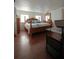 Main bedroom showcasing hardwood floors, a large bed, dresser and natural light at 2108 W Comanche Ave, Tampa, FL 33603