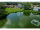 Aerial view of the home featuring a pond with a fountain and lush surrounding landscape at 2406 Dana Dr, Safety Harbor, FL 34695