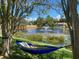 Serene backyard view with a hammock overlooking a tranquil pond and fountain at 2406 Dana Dr, Safety Harbor, FL 34695