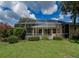 Lovely backyard featuring a screened-in pool area surrounded by lush landscaping and lawn at 2406 Dana Dr, Safety Harbor, FL 34695