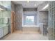 Ensuite bathroom with wallpaper, tub under a window and a glass block shower area at 2406 Dana Dr, Safety Harbor, FL 34695