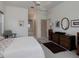 A bright bedroom with white ceiling fan, dresser and view into the hall and bathroom at 2406 Dana Dr, Safety Harbor, FL 34695