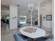 Bright dining space open to other living areas, featuring large table, windows, and chandelier at 2406 Dana Dr, Safety Harbor, FL 34695