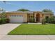 Inviting one-story home featuring a well-maintained lawn and a two-car garage with a long driveway at 2406 Dana Dr, Safety Harbor, FL 34695